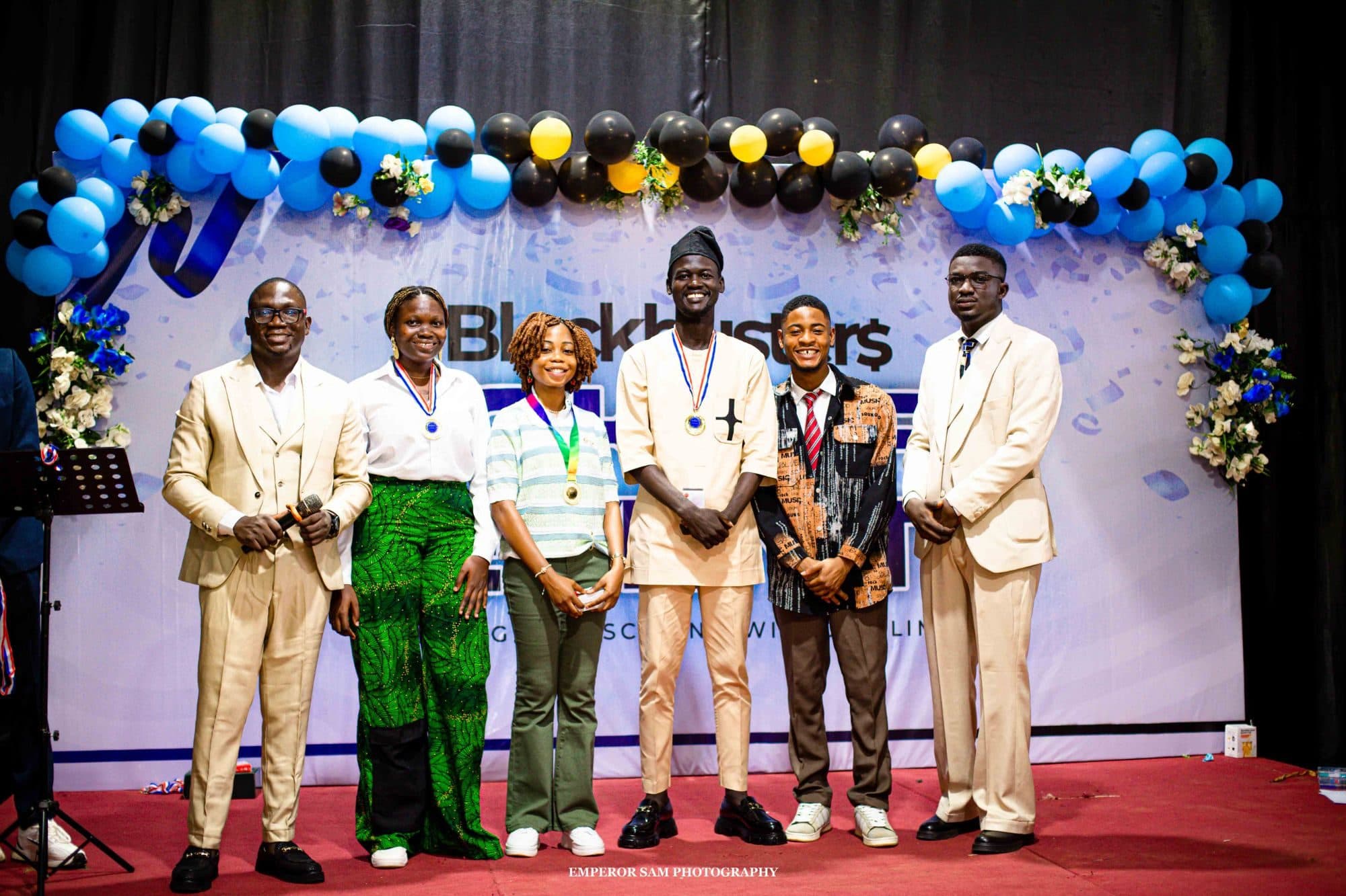Award winners with medals on stage with hosts